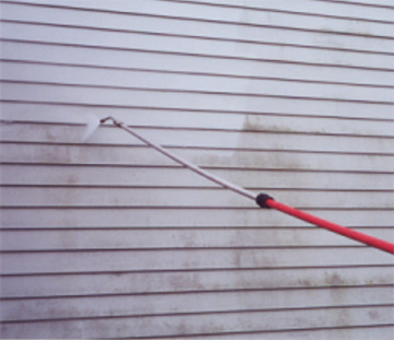 Pressure wash cleaning the siding of house